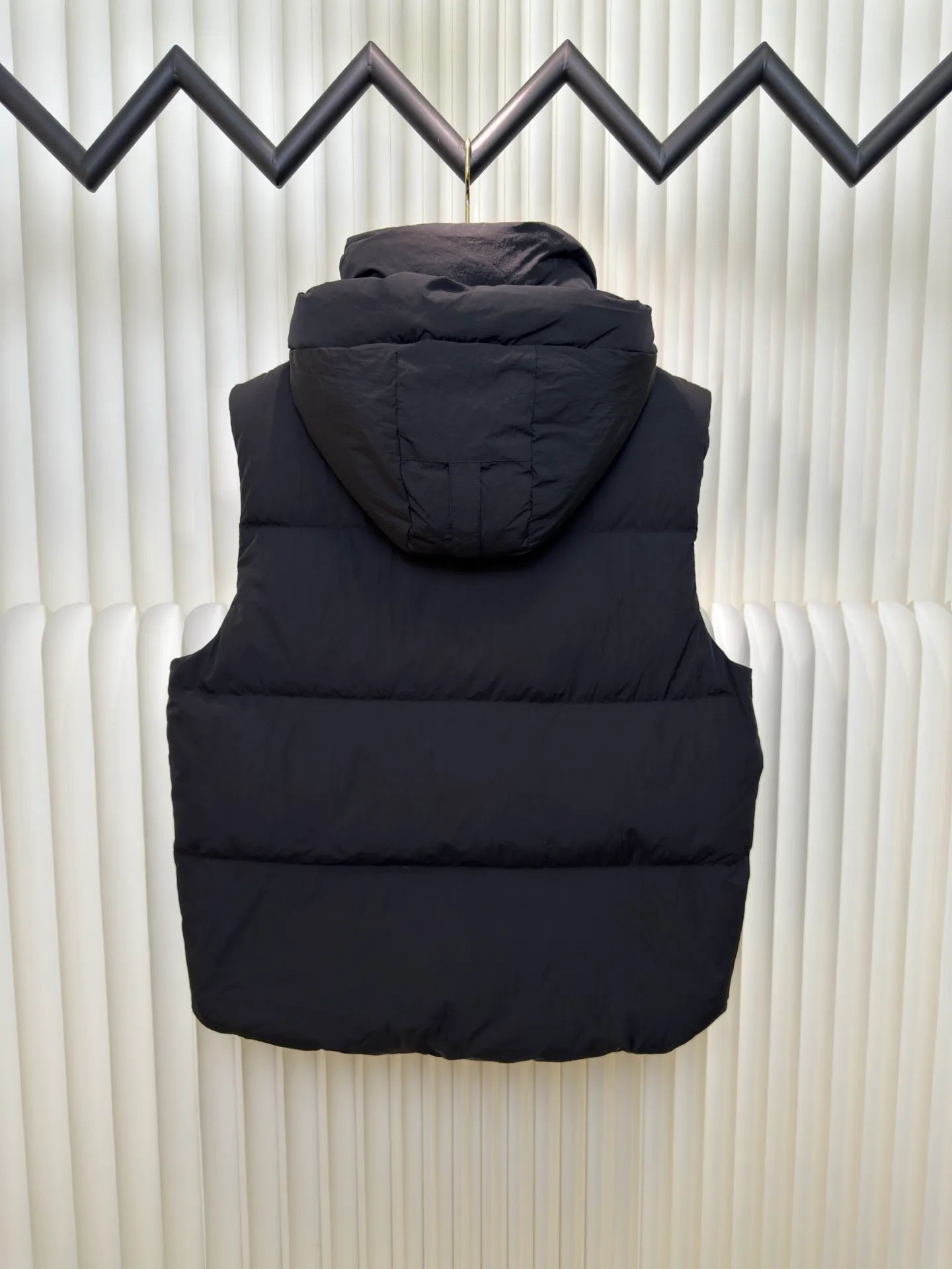 P760 Big Goose Logo Hooded Down Vest is made of high-quality protective nylon fabric, which not only enhances the wear resistance of the surface, but also takes into account wind resistance, ensuring excellent performance in various harsh weather conditions.  90 national standard high-quality white duck down: selected high-loft down, weighing 170g, light and warm, with excellent temperature locking performance and good resilience.  Three-dimensional quilting process: Precision thread reinforcement to prevent velvet drilling and ensure that the fluffy and resilient elasticity lasts as new.  Details: The ribbon is woven with polyester as the base. The brand letters are decorated on the ribbon through high-precision computer embroidery. The edges of the pattern are clear, the stitches are fine and even, and multiple layers of embroidery thread are stacked to enhance the three-dimensional effect. Size S M L XL